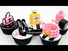 four cupcakes decorated with black and white frosting, pink and yellow decorations