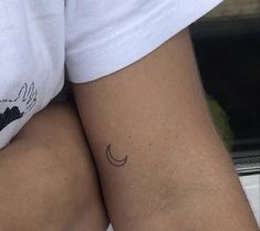 two people with tattoos on their legs and one has a small crescent tattoo on the lower arm