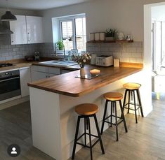 an image of a kitchen setting with stools and counter top in the foreground