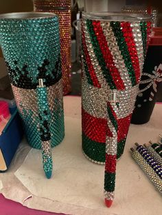 three different colored glass vases sitting on top of a table next to each other