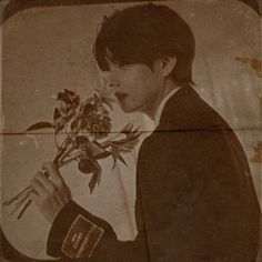 an old photo of a young man holding flowers