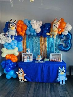 a blue table topped with balloons and decorations