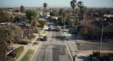 an aerial view of a street with houses and palm trees