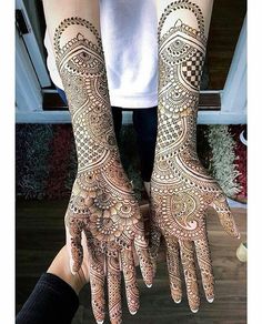 two hands with henna tattoos on them