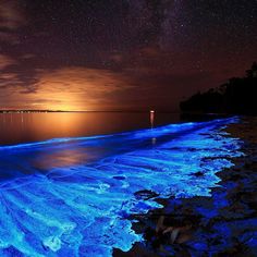 the water is glowing blue and it looks like waves are coming in from the ocean