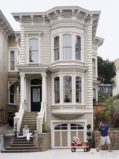 two people standing in front of a large house