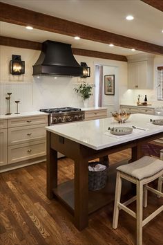 a large kitchen with an island in the middle and two stools at the end