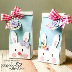 two paper bags with bunny ears and bows on the handles are sitting on a table