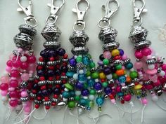 several different colored beads hanging from silver hooks