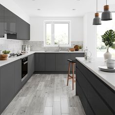 a kitchen with gray cabinets and white counter tops