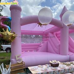 an inflatable pink castle with balloons and decorations