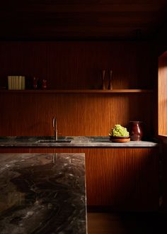 a kitchen with wooden cabinets and marble counter tops