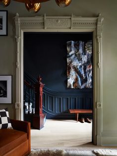 an open door leading to a living room filled with furniture and pictures on the wall