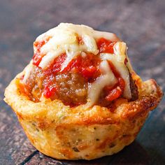 a small meatball cupcake with cheese and tomato sauce on it's top