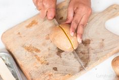 a person is cutting something on a wooden board