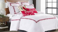 the comforter is white and red with embroidered trims on it's edges