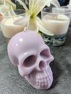 a pink skull candle holder next to some candles