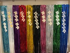 there are many different colored streamers hanging on the wall in front of each other