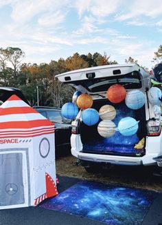 the back of a van with space themed decorations on it's trunk and door