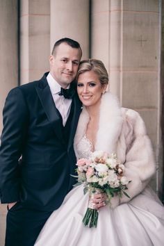 a bride and groom pose for a photo in front of an old building with columns