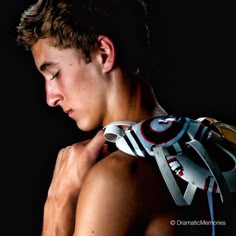 a young man wearing a neck brace and holding his hands on his chest