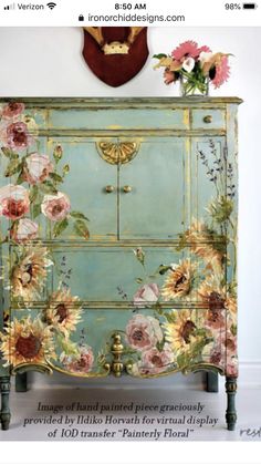 an old dresser painted with sunflowers and pink flowers on it's side