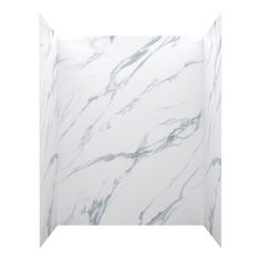 the corner of a bathroom with white marble walls and flooring, as well as an open shower stall