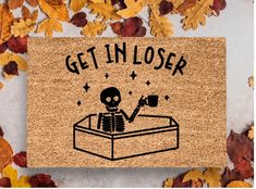 a door mat that says get in closer with a skeleton holding a cup on it