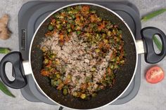 a pan filled with meat and vegetables on top of a table next to some green beans