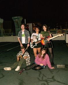 a group of young people posing with guitars