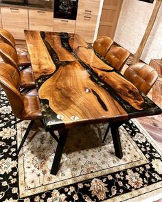 a dining table made out of wood with leather chairs around it and rug on the floor