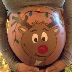 a pregnant woman wearing reindeer decorations on her belly