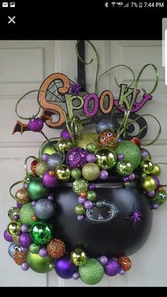 a halloween wreath hanging on the front door with decorations around it and spooky