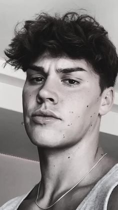 a black and white photo of a young man with freckles on his face