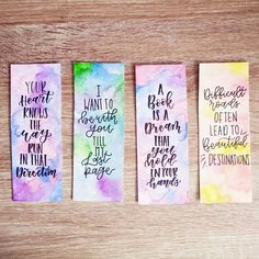 three watercolor bookmarks with handwritten words on them