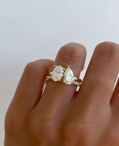 a woman's hand with two diamond rings on it