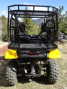 a yellow four - wheeler parked in the grass