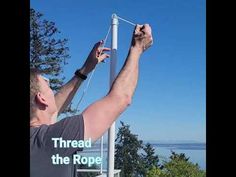 a man is working on the top of a pole with his hands in the air