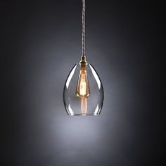 a light bulb that is hanging from a wire on a dark background with the light turned on