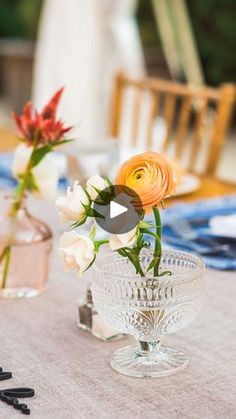 two vases filled with flowers sitting on top of a table