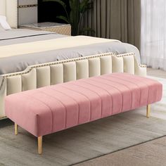 a pink bench sitting in front of a bed