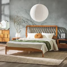 a bed sitting on top of a wooden floor next to a dresser under a light fixture