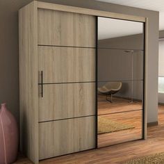 a large mirror on the wall above a wooden cabinet in a room with hardwood floors