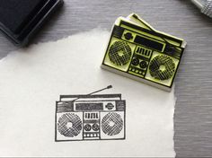 a rubber stamp with a radio and boombox on it next to a camera, pen and paper