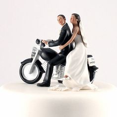 a wedding cake topper with a bride and groom riding a motorcycle on the side