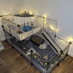 a caged bed with lights on the top and bottom is made out of metal wire