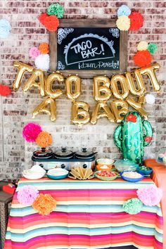 a taco bout bar decorated with balloons and decorations