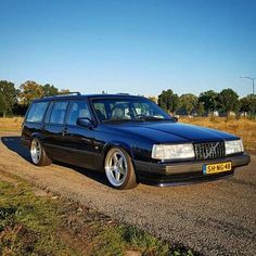 a black station wagon parked on the side of a road