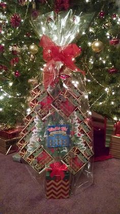 a christmas tree with presents wrapped in plastic and tied up to it's base