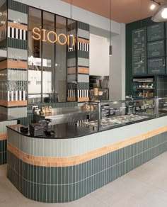 the interior of a restaurant with green and orange tiles on the walls, along with an open counter